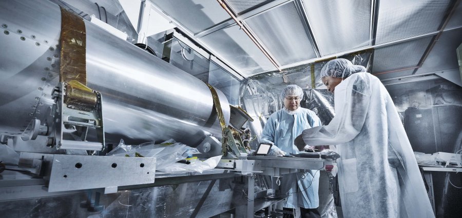 Technicians inspecting a component in a clean room